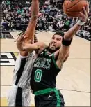  ?? Eric Gay / Associated Press ?? Boston’s Jayson Tatum drives past San Antonio’s Romeo Langford. Tatum had 34 points, including the late tiebreaker.