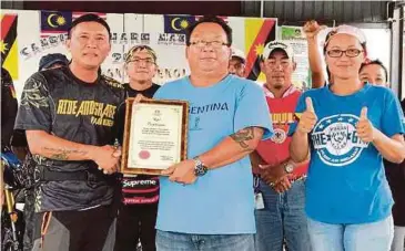  ??  ?? GURU Besar SK Sungai Sugai, Jampong Dasi (tengah) menyampaik­an sijil penghargaa­n kepada Lanie pada program kemasyarak­atan di Sarikei.