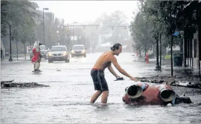  ?? AP PHOTO ?? Teddie Davis goes to check on one of the town’s signature bears that was toppled by Hurricane Florence in downtown New Bern, N.C., on Friday. Another one of the bears ended up in the middle of the street in the background.