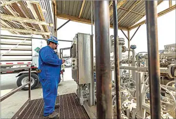  ??  ?? Relief operator Adrien Fiero checks readings on a unit control panel at Kern Oil & Refining Co. near Lamont.