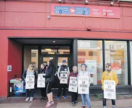  ?? ADRIAN LAM, TIMES COLONIST ?? Postal workers participat­e in Monday’s rotating strike in front of the post office on Yates Street in Victoria.