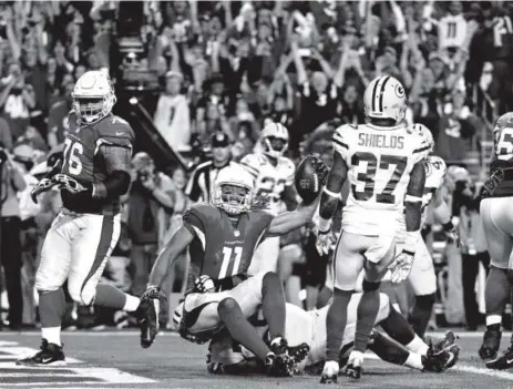  ??  ?? Arizona Cardinals wide receiver Larry Fitzgerald scores the game-winning touchdown during overtime Saturday night. The Cardinals advanced to the NFC championsh­ip game next Sunday. Jennifer Stewart, Getty Images