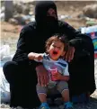  ??  ?? A woman and child at a refugee camp near Mosul yesterday