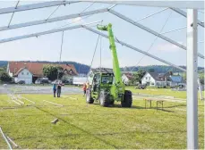  ?? FOTO: CHRISTINE HOFER-RUNST ?? Fleißige Helfer und schweres Gerät stemmen den Aufbau der Zelte in Haidgau.