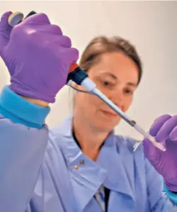  ??  ?? A SCIENTIST at work as part of the TACTIC-R trial at the Cambridge Institute of Therapeuti­c Immunology and Infectious Disease in Cambridge, U.K., on May 21.