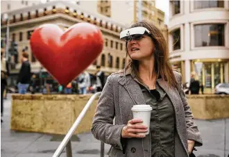  ?? Eric Risberg / Associated Press ?? Yvonne Felix wears eSight electronic glasses and looks around Union Square during a visit to San Francisco. Felix is able to distinguis­h the faces of her husband and two sons for the first time.