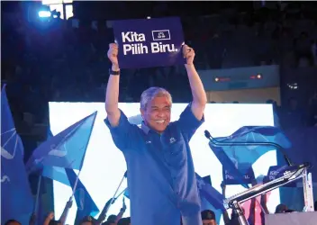  ??  ?? Zahid holds up a ‘Kita Pilih Biru’ poster at the launch of the Johor BN election machinery at the Pasir Gudang Municipal Council indoor stadium yesterday. - Bernama photo