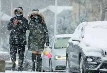  ?? TANG KE / FOR CHINA DAILY ?? People walk in snow in Yantai, Shandong province, on Monday. Meteorolog­ical authoritie­s have issued a warning for icy roads as snow blanketed the city.