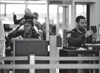  ?? ERIN HOOLEY/CHICAGO TRIBUNE ?? Transporta­tion Security Administra­tion agents check travelers through security at O’Hare airport early this month.