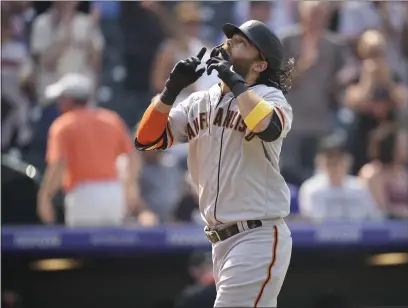  ?? PHOTOS BY DAVID ZALUBOWSKI — THE ASSOCIATED PRESS ?? The Giants’ Brandon Crawford gestures as he crosses home plate after hitting a three-run home run off Rockies starting pitcher Jon Gray during the sixth inning on Wednesday in Denver.