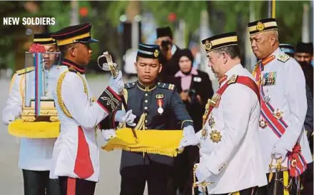  ?? PIC BY KHAIRULL AZRY BIDIN ?? Yang di-Pertuan Agong Sultan Muhammad V presenting the ‘Best Overall Cadet Officer’ award to Muhd Hafiz Muhd Yusoff during the royal commission­ing parade of Universiti Pertahanan Nasional Malaysia cadet officers at Kem Perdana Sungai Besi, Kuala Lumpur.