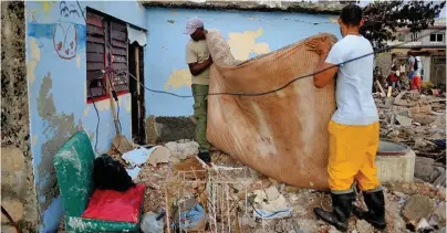  ??  ?? Cubans recover their belongings after the passage of Hurricane Irma.