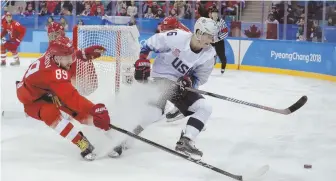  ?? AP PHOTO ?? STAR ON THE RISE: Ryan Donato of the United States (right) battles Nikita Nesterov for the puck during Saturday’s preliminar­y-round game won by the Russians in Gangneung, South Korea.