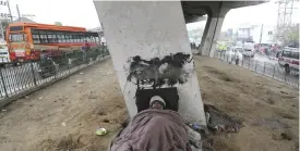  ??  ?? JAMMU: A homeless Indian sleeps covered with a blanket under a flyover on a cold winter day in Jammu yesterday. Some 800 million people in the country live in poverty, many of them migrating to big cities in search of a livelihood and often ending up...