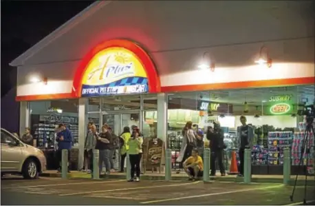  ?? RICK KAUFFMAN – DIGITAL FIRST MEDIA ?? A crowd had gathered outside the Sunoco A-Plus and the Wendy’s parking Wednesday night. lot across from the scene of the standoff