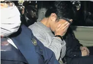  ??  ?? SHAME: Takahiro Shiraishi covers his face after a raid in an apartment complex, right, where nine bodies were found