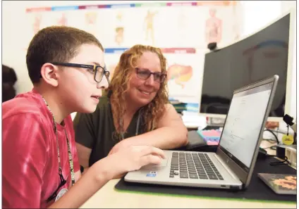  ?? Tyler Sizemore / Hearst Connecticu­t Media ?? Isaac Lopez, 11, uses his laptop with his mother, Jodi Clark-Lopez, at their home in Stamford on Monday. Stamford has announced that it would not offer remote learning for the upcoming school year, so Clark-Lopez started a change.org petition calling on Stamford schools to offer a remote option in the fall.