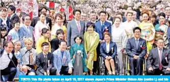  ??  ?? TOKYO: This file photo taken on April 15, 2017 shows Japan’s Prime Minister Shinzo Abe (centre L) and his wife Akie (centre R) posing with entertaine­rs and athletes during the cherry blossom viewing party hosted by the prime minister. — AFP