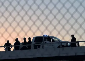  ?? Mark Ralston, AFP/Getty Images ?? U.S. Border Patrol officers guard the fence separating the United States and Mexico in the city of El Paso, Texas.