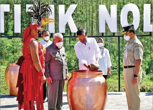  ?? SECRETARIA­T PRESS BUREAU INDONESIAN PRESIDENTI­AL ?? President Joko ‘Jokowi’ Widodo (centre) pours water brought by Jakarta governor Anies Baswedan (right), as East Kalimantan governor Isran Noor (third left) looks on, during a Kendi Nusantara ritual at the site for Indonesia’s new capital city Nusantara, on Monday.