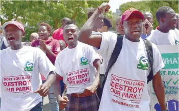  ?? — AFP ?? Environmen­tal activists chant slogans as they carry placards and banners during a protest in Nairobi on Thursday, against a government decision to construct a standard-gauge railway line across the Nairobi National Park.