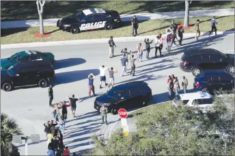  ?? MIKE STOCKER/SOUTH FLORIDA SUN-SENTINEL ?? Students hold their hands in the air as they are evacuated by police from Marjory Stoneman Douglas High School in Parkland, Fla., after a shooter opened fire on the campus.