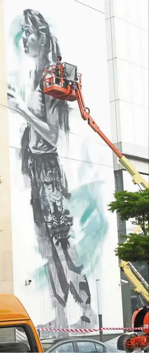  ?? ASRI ABDUL GHANI / The Star ?? Masterpiec­e in the works: Jarus using a boomlift to work on the mural at 1st Avenue Mall in Magazine Road, Penang. —