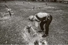  ?? Jon Shapley / Staff photograph­er ?? Paul De La Cerda cleans his grandmothe­r’s headstone after visiting his father’s gravesite at Forest Lawn Cemetery.
