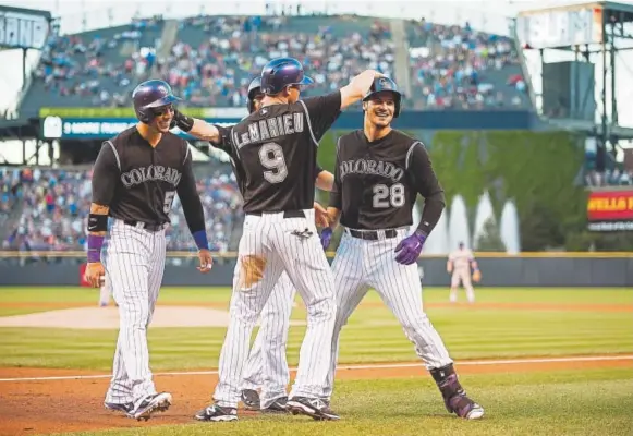  ?? Dustin Bradford, Getty Images ?? From left, Carlos Gonzalez, DJ Lemahieu, Charlie Blackmon (in front of Lemahieu) and Nolan Arenado scored on Arenado’s first-inning grand slam against the Dodgers at Coors Field on Sept. 26, 2015. It was Arenado’s 40th home run that season. “Cargo,...