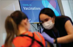  ?? The Associated Press ?? Nurse Sofia Mercado, right, administer­s a vaccine at an event for workers at an Amazon Fulfillmen­t Center on March 31 in North Las Vegas, Nev.