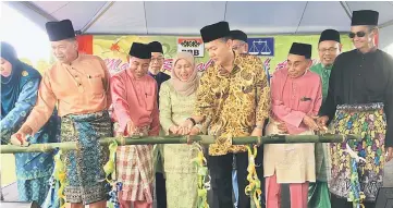  ??  ?? Nancy (fourth left), Ahmad (fifth left), Abd Rahman (third left) and others lighting the lamps as a gimmick to launch the Hari Raya Aidilfitri event organised by PBB Batu Kitang branch at the compound of Darul Ehsan Mosque at Kampung Haji Baki.