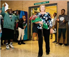  ?? REBECCA WRIGHT / FOR THE AJC ?? Collins Hill High School Principal Kerensa Wing is greeted with flowers, applause, cheers and accolades for her dedication to her students and teachers Monday at a ceremony recognizin­g her as National Principal of the Year.