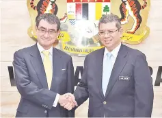  ?? — AFP photo ?? Japan’s Foreign MinisterTa­ro Kono (left) shaking hands with Malaysian Minister of Foreign Affairs Saifuddin Abdullah (right) during a visit in Putrajaya.