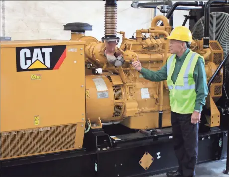  ?? Doug Walker / RN-T ?? Green Carbon co-founder Phil Wilson checks the Caterpilla­r synthetic gas-powered generator that is used to power the Thermal Vacuum Reactors.