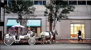  ??  ?? A horse and carriage
wait outside a Tiffany and Co. store in Cincinnati.
Bloomberg News/TY WRIGHT