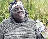  ??  ?? Gwendolyn Ellis praying over a bottle of healing water that she is about to give to the Western Star team to use against any form of sickness.