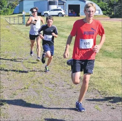  ?? ERIC MCCARTHY/JOURNAL PIONEER ?? Morgan Brennan leads the way in a close finish to the Prince County Exhibition’s 5K race on Saturday. His brother, Maguire, was just one second behind, and Jennifer Pizio-Perry crossed a second later.