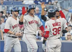  ?? Julie Jacobson / Associated Press ?? Boston’s Rafael Devers, second from left, is congratula­ted by teammates after hitting a grand slam against the Yankees in the first inning Saturday.