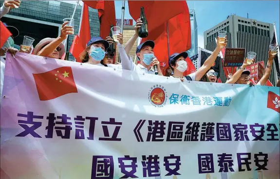  ?? CALVIN NG / CHINA DAILY ?? Hong Kong residents celebrate the enactment of the National Security Law for Hong Kong on June 30, 2020, in Tamar Park, Hong Kong.