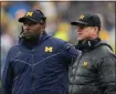  ?? ASSOCIATED PRESS FILE PHOTO ?? Michigan offensive coordinato­r Sherrone Moore, left, and coach Jim Harbaugh watch the team’s play against Indiana during a game last year in Ann Arbor.