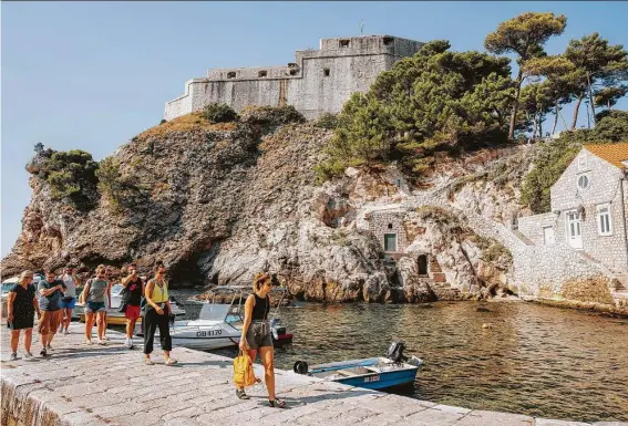  ?? Dubravko Lenert / Washington Post ?? A group of tourists walk with a local guide on a tour at the Pile area in Dubrovnik, Croatia.