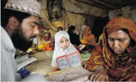  ?? Muhammed Muheisen/the Associated Press/files ?? Pakistani woman, Halimah Tajj, 51, right, repeats after her teacher Mohammad Shiraz, 24, left, during a daily class, teaching illiterate women and children how to read.