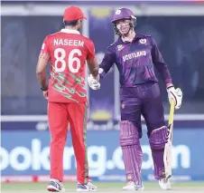  ?? — AFP photo ?? Oman’s wicketkeep­er Naseem Khushi (left) shakes hands with Scotland’s Richie Berrington as Scotland won the match at the Oman Cricket Academy Ground in Muscat.