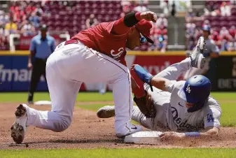  ?? Dylan Buell / Getty Images ?? Cincinnati’s Donovan Solano tags out the Dodgers’ Austin Barnes at third base Thursday. Solano, who won a Silver Slugger with the Giants, was back in San Francisco on Friday night.