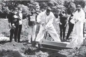  ?? Ap/andre Penner ?? People attend the burial of a relative who died from complicati­ons related to Covid-19 at the Vila Formosa cemetery in São Paulo, Brazil on April 7.