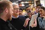  ??  ?? Apple CEO Tim Cook gets a demonstrat­ion of an app during the Chicago event held to introduce the new 9.7-inch Apple iPad.