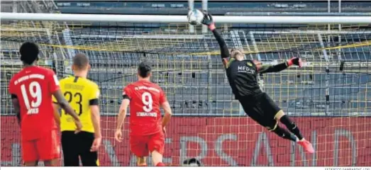  ?? FEDERICO GAMBARINI / DFL ?? El meta del Dortmund Roman Bürki no evita el gol de vaselina de Kimmich pese a su estirada.