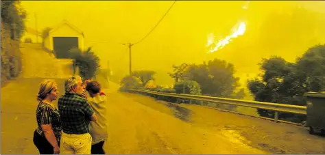  ?? BILD: DPA ?? Bewohner des Ortes Aldeia do Pessegueir­o nordöstlic­h von Lissabon schauen auf den Waldbrand.