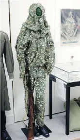  ??  ?? A Second World War Soviet women’s camouflage­d sniper uniform is displayed with a sniper rifle as part of an exhibition on women in wartime.