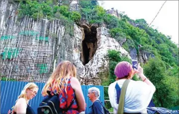  ?? HONG MENEA ?? In early evening, stainless steel tables with red plastic chairs are placed along the road next to Phnom Sampov for visitors to sit and watch the bats fly out of the cave.